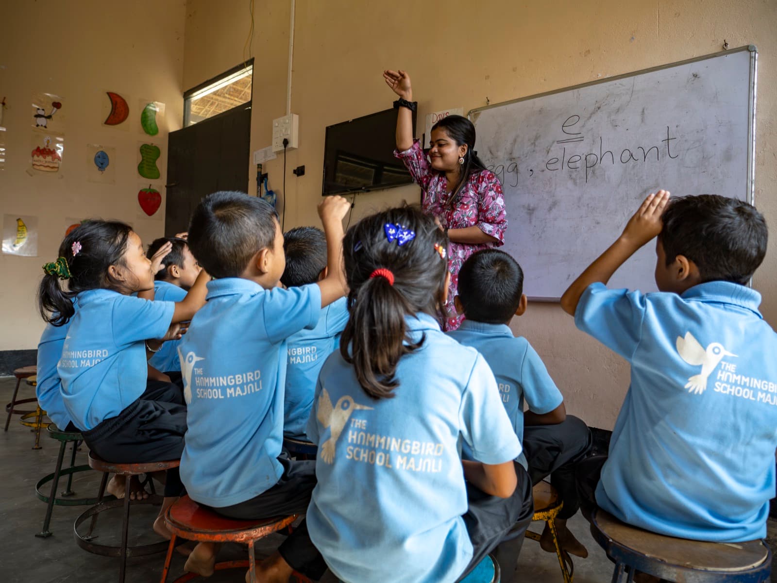 A Hummingbird classroom in session, students with hands raised, teacher at the board