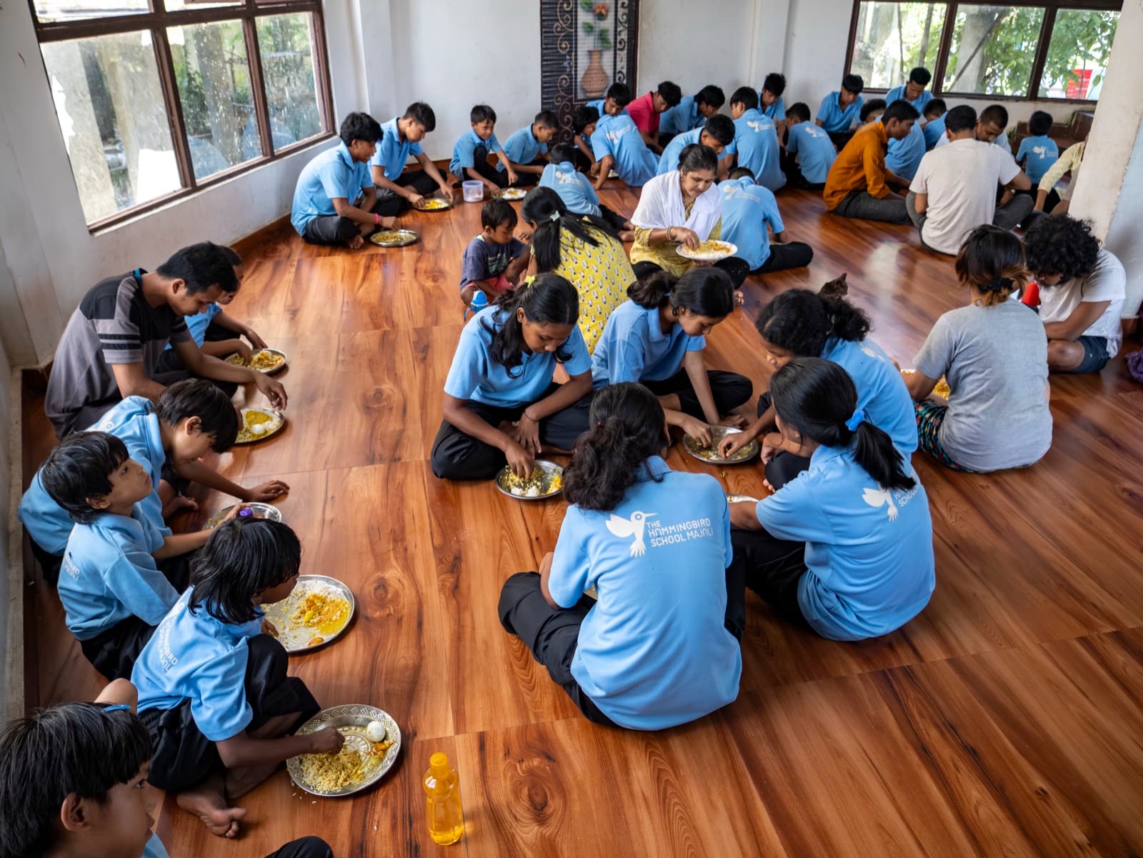 Children eating together in a circle at the Home